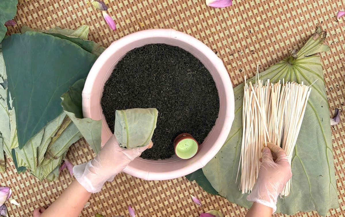 Chậu trà khô đặt trên lá sen xanh cùng que tre và lá lót