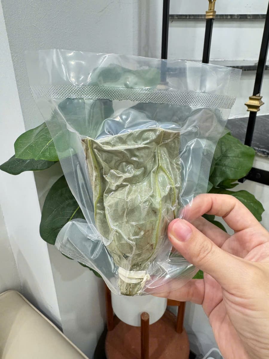 Túi trong suốt đựng bông trà sen đã sấy khô, cầm trên tay